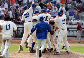NEW YORK - AUGUST 16:  Daniel Murphy #28 of the New York Mets is mobbed by his teammates after his game winning hit against the San Francisco Giants on August 16, 2009 at Citi Field in the Flushing neighborhood of the Queens borough of New York City.  (Photo by Jim McIsaac/Getty Images)