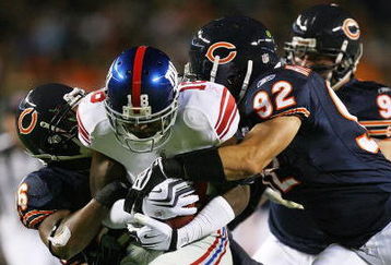 CHICAGO - AUGUST 22: Hakeem Nicks #18 of the New York Giants is tackled by Josh Bullocks #36 and Hunter Hillenmeyer #92 of the Chicago Bears during a pre-season game on August 22, 2009 at Soldier Field in Chicago, Illinois. The Bears defeated the Giants 17-3. (Photo by Jonathan Daniel/Getty Images)