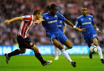 SUNDERLAND, ENGLAND - AUGUST 18:  Phil Bardsley of Sunderland challenges Didier Drogba of Chelsea during the Barclays Premier League match between Sunderland and Chelsea at the Stadium of Light on August 18, 2009 in Manchester, England. (Photo by Michael Regan/Getty Images)