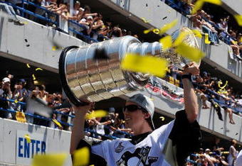 PITTSBURGH - JUNE 15:  Marc-Andre Fleury #29 of the Pittsburgh Penguins holds aloft the Stanley Cup for the crowd on the Blvd of the Allies during Stanley Cup Champion Victory Parade on June 15, 2009 in Pittsburgh, Pennsylvania.  (Photo by Jamie Sabau/Getty Images)