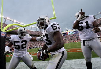 DENVER - SEPTEMBER 16:  Thomas Howard #53 of the Oakland Raiders celebrates his interception for a touchdown with Kirk Morrison #52 and Gerard Warren #61 against the Denver Broncos as the Broncos defeated the Raiders 23-20 in overtime during week two NFL action at Invesco Field at Mile High on September 16, 2007 in Denver, Colorado.  (Photo by Doug Pensinger/Getty Images)