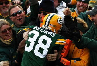 GREEN BAY, WI - NOVEMBER 18: Tramon Williams #38 of the Green Bay Packers is congratulated by fans after leaping into the stands following a punt return for a touchdown against the Carolina Panthers on November 18, 2007 at Lambeau Field in Green Bay, Wisconsin. (Photo by Jonathan Daniel/Getty Images)