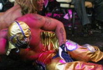 LAS VEGAS - DECEMBER 2:  (U.S. TABLOIDS OUT)   WWE wrestlers Rey Mysterio (in gold) and Chris Jericho perform on stage during the '1st Annual Video Game Awards' at the MGM Grand Garden Arena December 2, 2003 in Las Vegas, Nevada.  The show premieres on Spike T.V. Thursday, December 4 at 9:00PM ET/PT.  (Photo by Frank Micelotta/Getty Images)
