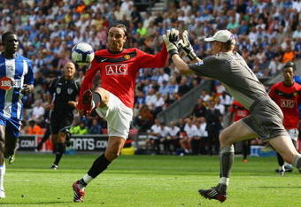 WIGAN, ENGLAND - AUGUST 22:  Dimitar Berbatov of Manchester United chips the ball over Chris Kirkland of Wigan Athletic on his way to scoring the second goal during the Barclays Premier League match between Wigan Athletic and Manchester United at the DW Stadium on August 22, 2009 in Wigan, England.  (Photo by Alex Livesey/Getty Images)
