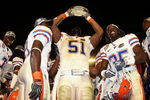 MIAMI - JANUARY 08:  Brandon Spikes #51 of the Florida Gators celebrate with the trophy after defeating the Oklahoma Sooners in the FedEx BCS National Championship Game at Dolphin Stadium on January 8, 2009 in Miami, Florida. The Gators won the game by a score of 24-14.  (Photo by Donald Miralle/Getty Images)