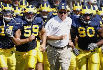 ANN ARBOR, MI - AUGUST 30:  Head coach Rich Rodriguez of the Michigan Wolverines leads his team onto the field between Tim Jamison #90 and Sean Griffin #59 prior to playing the Utah Utes on August 30, 2008 at Michigan Stadium in Ann Arbor, Michigan.  (Photo by Gregory Shamus/Getty Images)