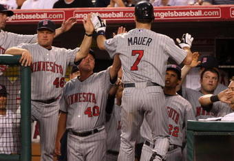 ANAHEIM, CA - JULY 24:  Joe Mauer #7 of the Minnesota Twins is greeted after hitting a home run in the fourth inning against the Los Angeles Angels of Anaheim on July 24, 2009 at Angel Stadium in Anaheim, California.  (Photo by Stephen Dunn/Getty Images)