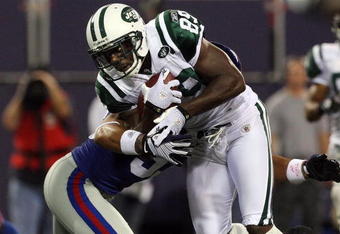 EAST RUTHERFORD, NJ - AUGUST 29:  Jerricho Cotchery #89 of the New York Jets runs the ball against Bryan Kehl #53 of the New York Giants on August 29, 2009 at Giants Stadium in East Rutherford, New Jersey.  (Photo by Jim McIsaac/Getty Images)