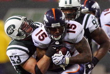 EAST RUTHERFORD, NJ - NOVEMBER 30:  Brandon Marshall #15 of the Denver Broncos is tackled by Cody Spencer #53 of the New York Jets on November 30, 2008 at Giants Stadium in East Rutherford, New Jersey. The Broncos defeated the Jets 34-17.  (Photo by Jim McIsaac/Getty Images)