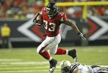 ATLANTA - AUGUST 29:  Running back Michael Turner #33 of the Atlanta Falcons is tripped up by cornerback Antoine Cason #20 of the San Diego Chargers during the game at the Georgia Dome on August 29, 2009 in Atlanta, Georgia.  The Falcons beat the Chargers 27-24.  (Photo by Mike Zarrilli/Getty Images)