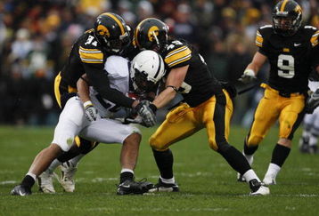IOWA CITY, IA - NOVEMBER 8:  Broderick Binns #91 and A.J. Edds #49 of the Iowa Hawkeyes tackle Evan Royster #22 Penn State Nittany Lions as he rushed for yards in the second quarter of play at Kinnick Stadium on November 8, 2008 in Iowa City, Iowa. Iowa defeated Penn State 24-23.  (Photo by David K Purdy/Getty Images)