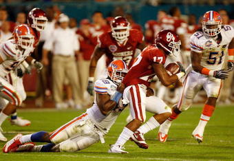 MIAMI - JANUARY 08:  Mossis Madu #17 of the Oklahoma Sooners gets tackled by Jermaine Cunningham #49 of the Florida Gators during the FedEx BCS National Championship Game at Dolphin Stadium on January 8, 2009 in Miami, Florida.  (Photo by Eliot J. Schechter/Getty Images)