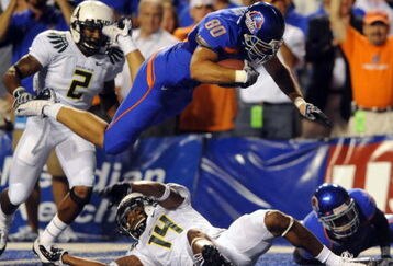 BOISE, ID - SEPTEMBER 3:  Kyle Elaw #80 of the Boise State Broncos dives over Javes Lewis #14 of the Oregon Ducks for a first down in first quarter of the game against the Oregon Ducks Boise State Broncos on September 3, 2009 at Broncos Stadium in Boise, Idaho. (Photo by Steve Dykes/Getty Images)