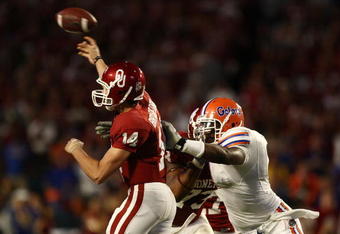 MIAMI - JANUARY 08:  Sam Bradford #14 of the Oklahoma Sooners gets pressured by Carlos Dunlap #8 of the Florida Gators as he throws during the FedEx BCS National Championship Game at Dolphin Stadium on January 8, 2009 in Miami, Florida.  (Photo by Donald Miralle/Getty Images)