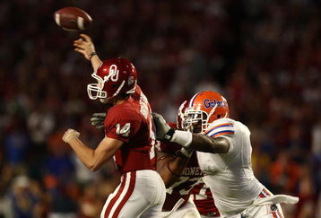 MIAMI - JANUARY 08:  Sam Bradford #14 of the Oklahoma Sooners gets pressured by Carlos Dunlap #8 of the Florida Gators as he throws during the FedEx BCS National Championship Game at Dolphin Stadium on January 8, 2009 in Miami, Florida.  (Photo by Donald Miralle/Getty Images)