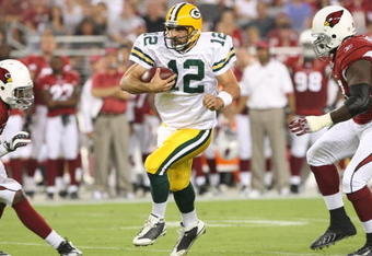 GLENDALE, AZ - AUGUST 28:  Quarterback Aaron Rodgers #12 of the Green Bay Packers rushes inbetween (L-R) Karlos Dansby #58 and Bryan Robinson #97 of the Arizona Cardinals during the first quarter at the University of Phoenix Stadium on August 28, 2009 in Glendale, Arizona.  (Photo by Christian Petersen/Getty Images)