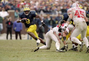 22 Nov 1997:  Tailback Chris Howard of the Michigan Wolverines (left) runs with the ball as linebacker Andy Katzenmoyer of the Ohio State Buckeyes (right) runs toward him during a game at Michigan Stadium in Ann Arbor, Michigan.  Michigan won the game 20-