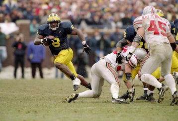 22 Nov 1997:  Tailback Chris Howard of the Michigan Wolverines (left) runs with the ball as linebacker Andy Katzenmoyer of the Ohio State Buckeyes (right) runs toward him during a game at Michigan Stadium in Ann Arbor, Michigan.  Michigan won the game 20-