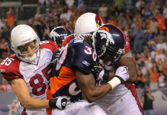 DENVER - SEPTEMBER 3: Safety David Bruton #30 of the Denver Broncos gets tackled by wide receiver Jerheme Urban #85 of the Arizona Cardinals after Bruton intercepted a pass by Cardinals quarterback Matt Leinart (not pictured) in the second quarter of the NFL preseason game at Invesco Field at Mile High on September 3, 2009 in Denver, Colorado.  (Photo by Doug Pensinger/Getty Images)