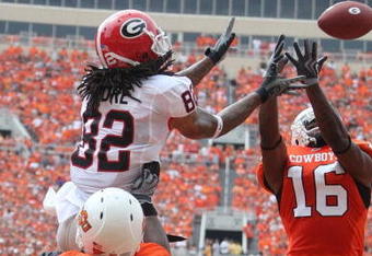 STILLWATER, OK - SEPTEMBER 5:  Wide receiver Michael Moore of the Georgia Bulldogs catches a pass for a touchdown between Perrish Cox #16 and Andre Sexton #20 of the Oklahoma State Cowboys during the first quarter of the game at Boone Pickens Stadium on September 5, 2009 in Stillwater, Oklahoma. (Photo by Christian Petersen/Getty Images)