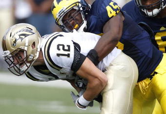 ANN ARBOR, MI - SEPTEMBER 05:  Obi Ezeh #45 of the Michigan Wolverines sacks Tim Hiller #3 of the Western Michigan Broncos on September 5, 2009 at Michigan Stadium in Ann Arbor, Michigan. Michigan won the game 31-7. (Photo by Gregory Shamus/Getty Images)