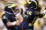 ANN ARBOR, MI - SEPTEMBER 05:  Tate Forcier #5 of the Michigan Wolverines celebrates with Denard Robinson #16 after Robinson ran for a long first quarter touchdown against the Western Michigan Broncos on September 5, 2009 at Michigan Stadium in Ann Arbor, Michigan.  (Photo by Gregory Shamus/Getty Images)