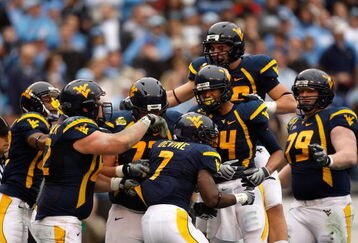 CHARLOTTE, NC - DECEMBER 27:  Noel Devine #7 of the West Virginia Mountaineers celebrates with his teammates after scoring a touchdown against the North Carolina Tar Heels during the Meineke Car Care Bowl on December 27, 2008 at Bank of America Stadium in Charlotte, North Carolina.  (Photo by Streeter Lecka/Getty Images)