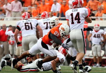 STILLWATER, OK - SEPTEMBER 5:   Dexter Pratt #22 of the Oklahoma State Cowboys pressures quarterback Joe Cox #14 of the Georgia Bulldogs during the second quarter of the game at Boone Pickens Stadium on September 5, 2009 in Stillwater, Oklahoma. (Photo by Christian Petersen/Getty Images)