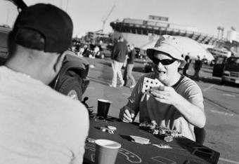 EAST RUTHERFORD, NJ - OCTOBER 21: Tailgaters play cards in the carpark after watching the NFL game between the San Francisco 49ers and the New York Giants at Giants Stadium on October 21, 2007 in East Rutherford, New Jersey. Born and bred into American sporting culture the act of tailgating is a tradition practiced unlike anywhere else in the world. Tailgating by definition is the act of partying or picnicking around a vehicle in a car park prior to the start of a sporting event. At any major sporting event in the United States you will find die hard fans, all settling into car parks surrounding the stadium, hours before the event even begins. Tailgaters, young and old drink, play games, barbeque and party, rain, hail or snow and often in unusual places, just about anywhere it?s possible to park a car and setup a barbeque. What started as a small pre-game picnic held out of the back of a pickup truck has now evolved into a multibillion-dollar business, with participant numbers estimated at over 50 million ove