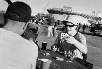 EAST RUTHERFORD, NJ - OCTOBER 21: Tailgaters play cards in the carpark after watching the NFL game between the San Francisco 49ers and the New York Giants at Giants Stadium on October 21, 2007 in East Rutherford, New Jersey. Born and bred into American sporting culture the act of tailgating is a tradition practiced unlike anywhere else in the world. Tailgating by definition is the act of partying or picnicking around a vehicle in a car park prior to the start of a sporting event. At any major sporting event in the United States you will find die hard fans, all settling into car parks surrounding the stadium, hours before the event even begins. Tailgaters, young and old drink, play games, barbeque and party, rain, hail or snow and often in unusual places, just about anywhere it?s possible to park a car and setup a barbeque. What started as a small pre-game picnic held out of the back of a pickup truck has now evolved into a multibillion-dollar business, with participant numbers estimated at over 50 million ove