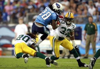 NASHVILLE, TN - SEPTEMBER 3: Chris Johnson #28 of the Tennessee Titans attempts to jump over defenders Atari Bigby #20 and Brandon Underwood #33 of the Green Bay Packers during a preseason NFL game at LP Field on September 3, 2009 in Nashville, Tennessee. (Photo by Joe Murphy/Getty Images)