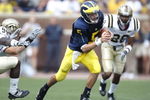 ANN ARBOR, MI - SEPTEMBER 05:  Tate Forcier #5 of the Michigan Wolverines looks for running room in front of Keith Dixson #28 of the Western Michigan Broncos on September 5, 2009 at Michigan Stadium in Ann Arbor, Michigan.  (Photo by Gregory Shamus/Getty Images)