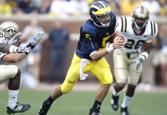 ANN ARBOR, MI - SEPTEMBER 05:  Tate Forcier #5 of the Michigan Wolverines looks for running room in front of Keith Dixson #28 of the Western Michigan Broncos on September 5, 2009 at Michigan Stadium in Ann Arbor, Michigan.  (Photo by Gregory Shamus/Getty Images)