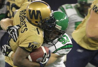 TORONTO, ON - NOVEMBER 25:  John Chick #97 of the Saskatchewan Rough Riders tackles Charles Roberts #1 of the Winnipeg Blue Bombers for a three yard loss during the first quarter of the 95th Grey Cup on November 25, 2007 at the Rogers Centre in Toronto, Ontario, Canada.  (Photo by Harry How/Getty Images)