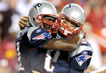 LANDOVER, MD - AUGUST 28:  Tom Brady #12 and Randy Moss #81 of the New England Patriots celebrate after scoring a touchdown in the second quarter of a preseason game against the Washington Redskins at FedExField on August 28, 2009 in Landover, Maryland.  (Photo by Greg Fiume/Getty Images)