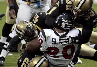 HOUSTON - AUGUST 22:  Running back Steve Slaton #20 is tackle by Chris Reis #39, Tracy Porter #22 and Roman Harper #41 on August 22, 2009 in Houston, Texas.  (Photo by Bob Levey/Getty Images)