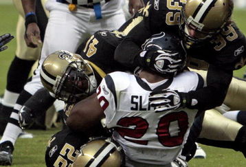 HOUSTON - AUGUST 22:  Running back Steve Slaton #20 is tackle by Chris Reis #39, Tracy Porter #22 and Roman Harper #41 on August 22, 2009 in Houston, Texas.  (Photo by Bob Levey/Getty Images)
