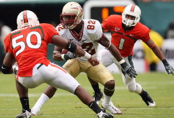 MIAMI - OCTOBER 04:  Wide receiver Taiwan Easterling #82 of the Florida State Seminoles tries to avoid being brought down by linebacker Darryl Sharpton #50 and defensive back Brandon Harris #1 of the Miami Hurricanes at Dolphin Stadium on October 4, 2008 in Miami, Florida.  (Photo by Doug Benc/Getty Images)