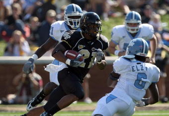 WINSTON SALEM, NC - OCTOBER 27:  Kenny Moore #21 of the Wake Forest Demon Deacons goes between Anthony Elzy #6 and Martel Thatch #21(behind)  of the UNC Tar Heels during the ACC game at the Groves Stadium, on October 27, 2007 in Winston Salem, North Carolina.  (Photo by David Cannon/Getty Images)