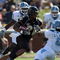 WINSTON SALEM, NC - OCTOBER 27: Kenny Moore #21 of the Wake Forest Demon Deacons goes between Anthony Elzy #6 and Martel Thatch #21(behind) of the UNC Tar Heels during the ACC game at the Groves Stadium, on October 27, 2007 in Winston Salem, North Carolina. (Photo by David Cannon/Getty Images)