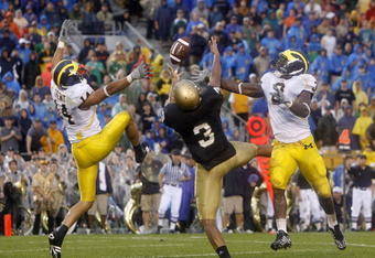 SOUTH BEND, IN - SEPTEMBER 13:  Michael Floyd #3 of the Notre Dame Fighting Irish can't hold onto a pass between Morgan Trent #14 and Stevie Brown #3 of the Michigan Wolverines on September 13, 2008 at Notre Dame Stadium in South Bend, Indiana. Notre Dame won the game 35-17.  (Photo by Gregory Shamus/Getty Images)