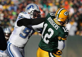 GREEN BAY, WI - DECEMBER 28: Aaron Rodgers #12 of the Green Bay Packers is hit by Dewayne White #99 of the Detroit Lions on December 28, 2008 at Lambeau Field in Green Bay, Wisconsin. The Packers defeated the Lions 31-21. (Photo by Jonathan Daniel/Getty Images)