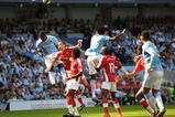 MANCHESTER, ENGLAND - SEPTEMBER 12:   Micah Richards of Manchester City heads the ball goalwards which leads to Manuel Almunia of Arsenal scoring an own goalduring the Barclays Premier League match between Manchester City and Arsenal at the City of Manchester Stadium on September 12, 2009 in Manchester, England. (Photo by Shaun Botterill/Getty Images)