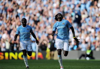MANCHESTER, ENGLAND - SEPTEMBER 12:  Emmanuel Adebayor of Manchester City celebrates with team-mate Kolo Toure after scoring during the Barclays Premier League match between Manchester City and Arsenal at the City of Manchester Stadium on September 12, 2009 in Manchester, England.  (Photo by Shaun Botterill/Getty Images)