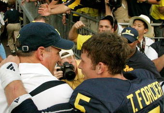 ANN ARBOR, MI - SEPTEMBER 12:  Quarterback Tate Forcier #5 embraces head coach Rich Rodriguez as they approach the tunnel after beating Notre Dame 38-34 at Michigan Stadium on September 12, 2009 in Ann Arbor, Michigan.  (Photo by Domenic Centofanti/Getty Images)