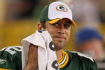 GREEN BAY, WI - SEPTEMBER 13: Aaron Rodgers #12 of the Green Bay Packers smiles at a teammate on the sidelines after throwing the winning touchdown pass against the Chicago Bears on September 13, 2009 at Lambeau Field in Green Bay, Wisconsin. The Packers defeated the Bears 21-15. (Photo by Jonathan Daniel/Getty Images)