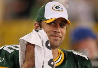 GREEN BAY, WI - SEPTEMBER 13: Aaron Rodgers #12 of the Green Bay Packers smiles at a teammate on the sidelines after throwing the winning touchdown pass against the Chicago Bears on September 13, 2009 at Lambeau Field in Green Bay, Wisconsin. The Packers defeated the Bears 21-15. (Photo by Jonathan Daniel/Getty Images)