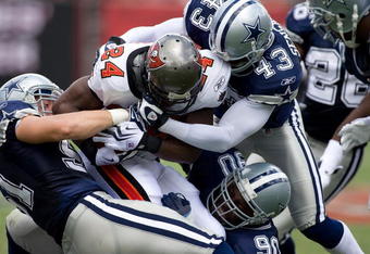 TAMPA, FL - SEPTEMBER 13:  Running back Carnell Williams #24 of the Tampa Bay Buccaneers is tackled by linebacker Keith Brooking #51, safety Gerald Sensabaugh #43 and nose tackle Jay Ratliff #90 of the Dallas Cowboys during the game at Raymond James Stadium on September 13, 2009 in Tampa, Florida.  (Photo by J. Meric/Getty Images)