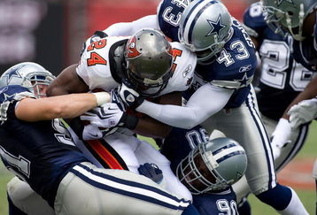 TAMPA, FL - SEPTEMBER 13:  Running back Carnell Williams #24 of the Tampa Bay Buccaneers is tackled by linebacker Keith Brooking #51, safety Gerald Sensabaugh #43 and nose tackle Jay Ratliff #90 of the Dallas Cowboys during the game at Raymond James Stadium on September 13, 2009 in Tampa, Florida.  (Photo by J. Meric/Getty Images)