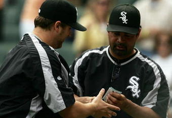CHICAGO - JUNE 10:  Manager Ozzie Guillen #13 of the Chicago White Sox (R) hands the line-up card to pitcher Mark Buehrle #56 after Buehrle notched his 100th career win against the Houston Astros on June 10, 2007 at U.S. Cellular Field in Chicago, Illinois. The White Sox defeated the Astros 6-3.  (Photo by Jonathan Daniel/Getty Images)